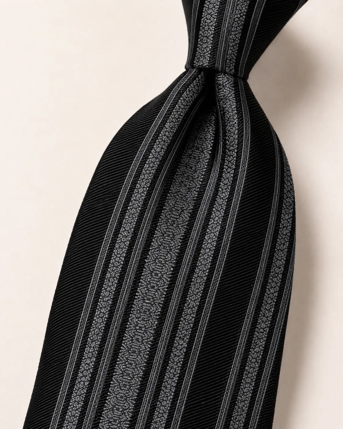 Black and silver Hakata-ori silk tie showing strong woven ribs and pattern texture